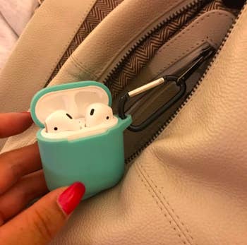 airpods in teal case attached to backpack