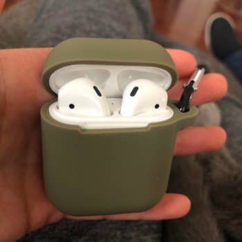 reviewer holding airpods with green case