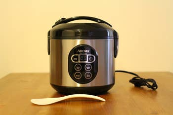 The stainless steel rice cooker showing buttons for several modes of cooking 
