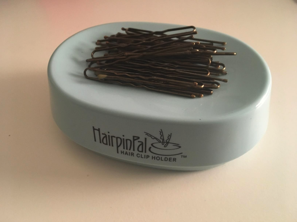 a set of bobby pins sitting in a blue container that looks similar to a plastic soap dish