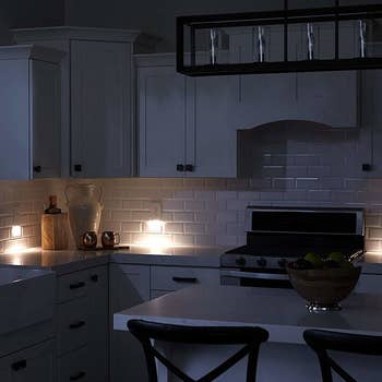 A kitchen in the dark with several outlets glowing 