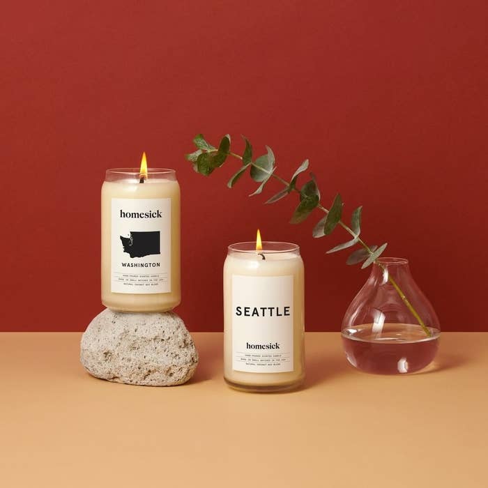two medium-sized candles, one says &quot;Seattle&quot; on it while the other says &quot;washington&quot; and shows the shape of washington state