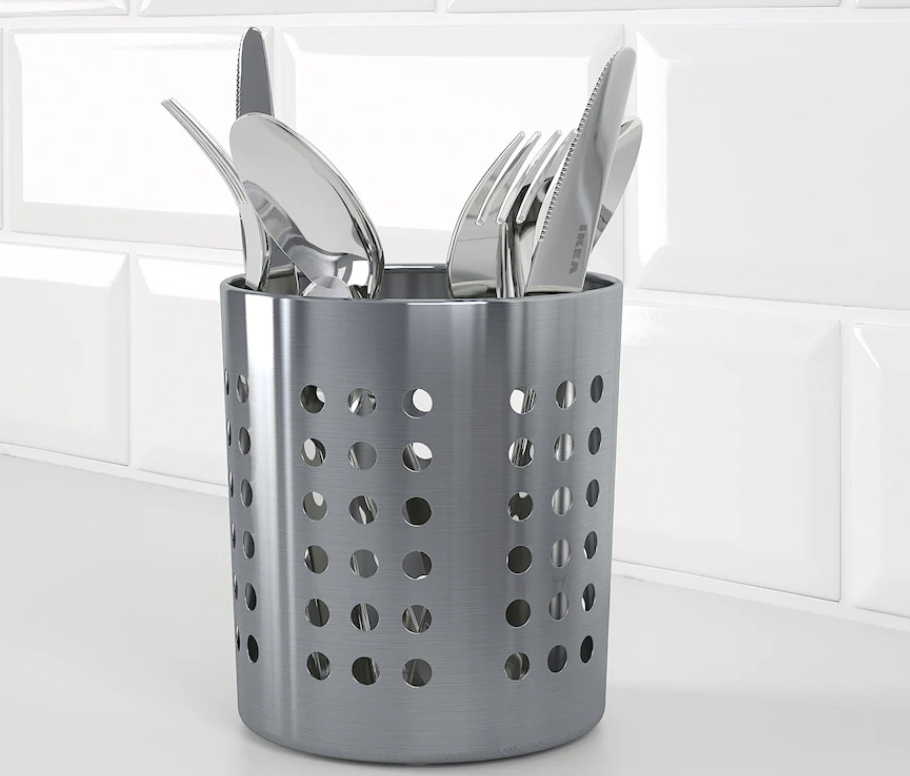 A stainless steel cutlery holder on a counter with many items in it.