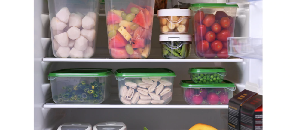 Multiple food containers with different items stored inside a fridge.