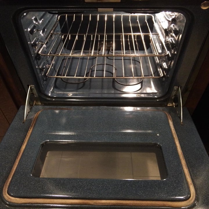 An after image of the same oven looking shiny and stain-free 