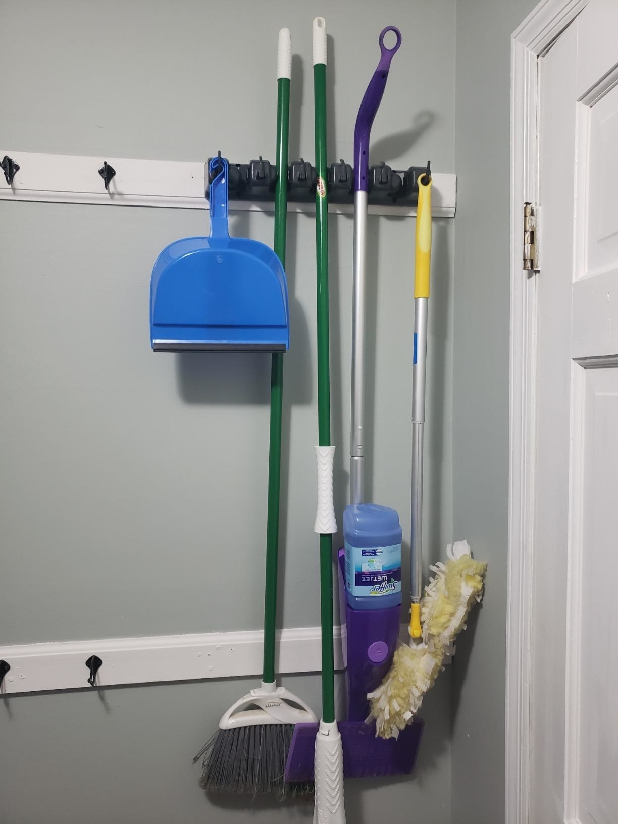 A reviewer&#x27;s broom and mops hanging on the organizer