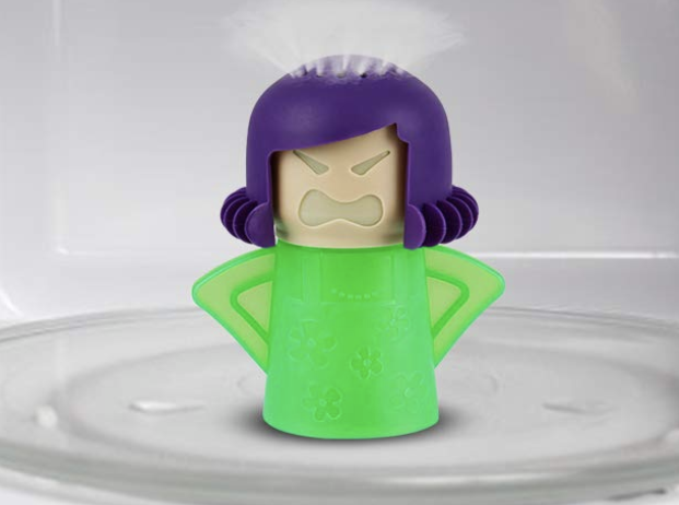 Green and purple &quot;Angry person&quot; cleaner filled with vinegar and steam coming out of the head inside a microwave