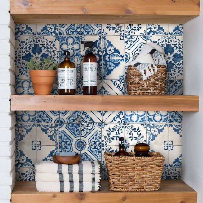 Blue and white faux tile behind bathroom shelves 