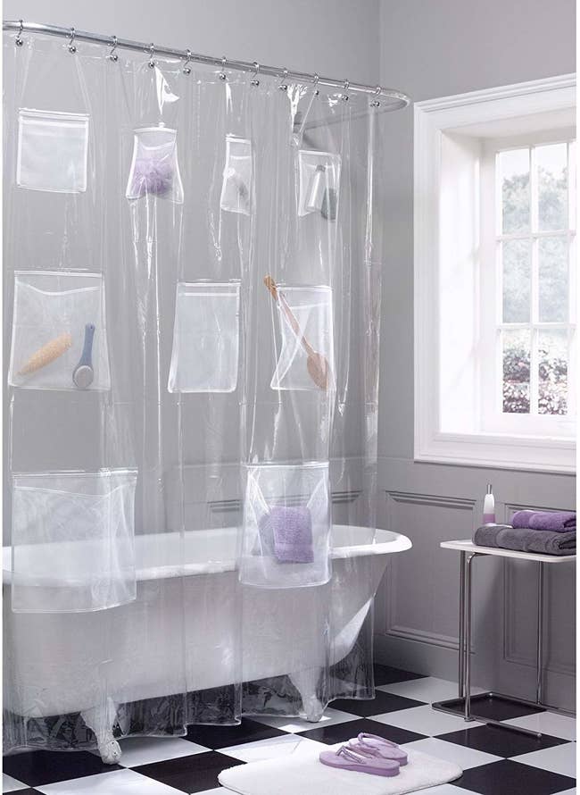 clear shower curtain with eight pockets of various sizes and items in them 