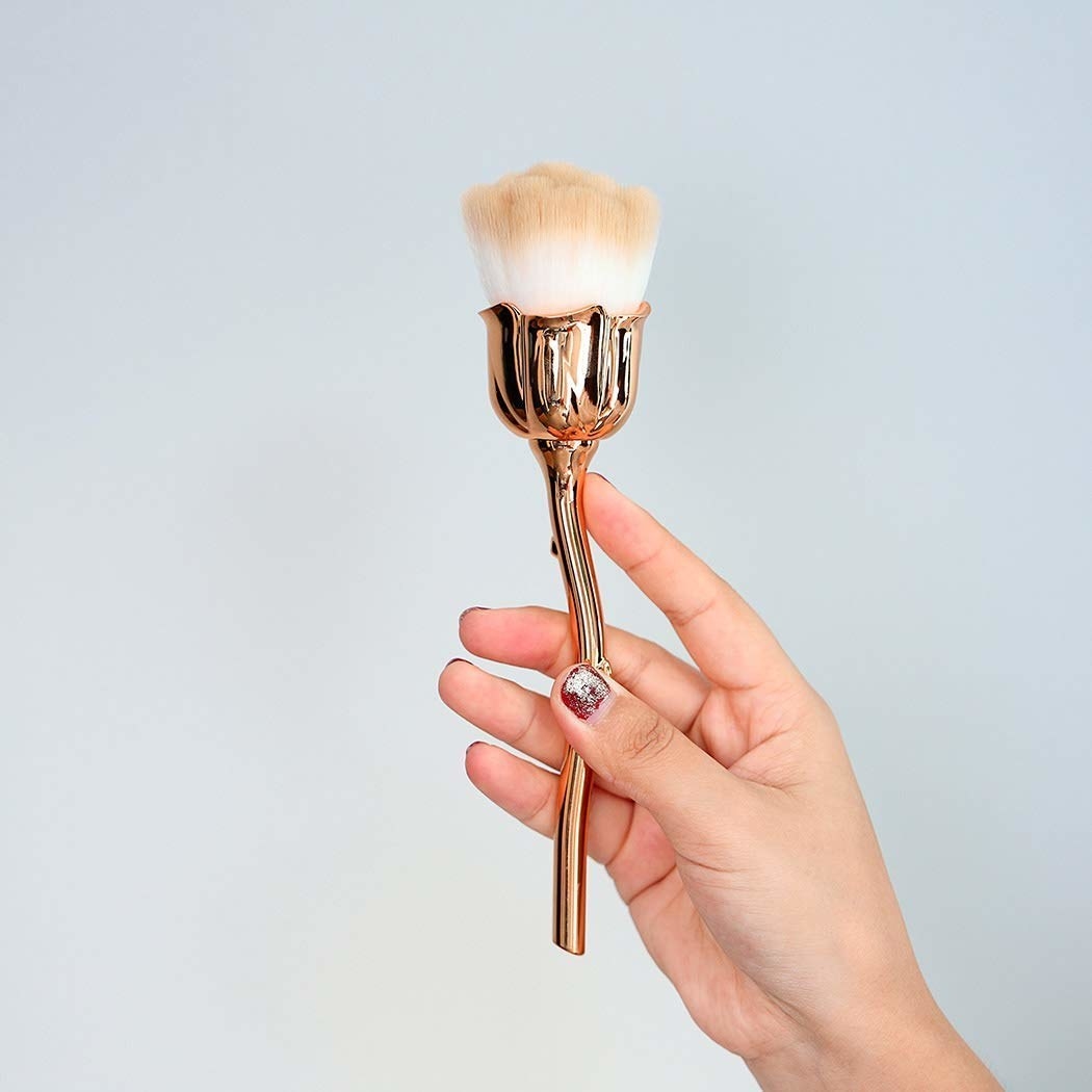a model holding the brush in gold
