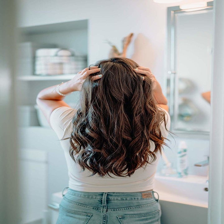 A model running her hands through her long, wavy hair