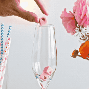gif of cubes dissovling in glass with champagne 