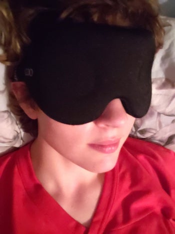reviewer wearing black sleep mask 