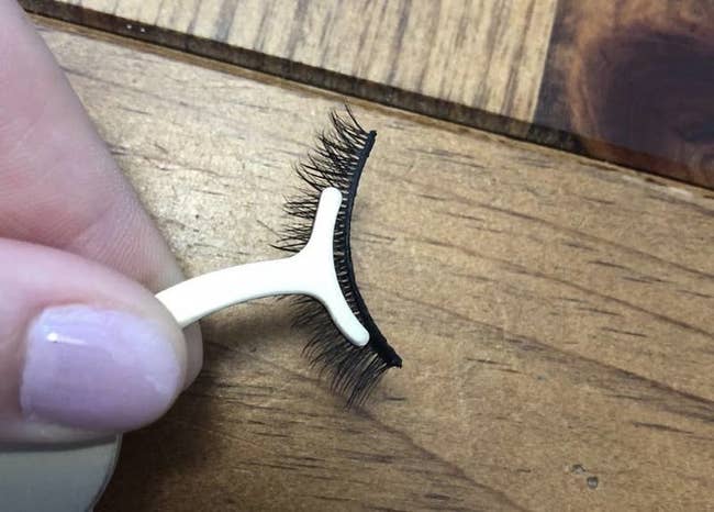 reviewer pic of the small thin applicator in white with a false eyelash attached to the y-shaped end