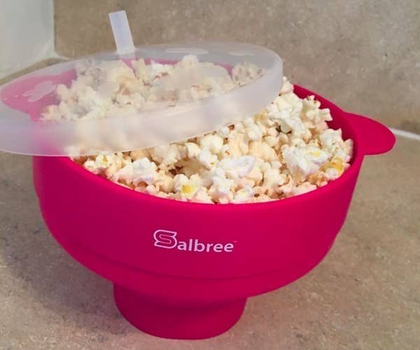 a reviewer photo of the popcorn bowl in magenta filled with popcorn