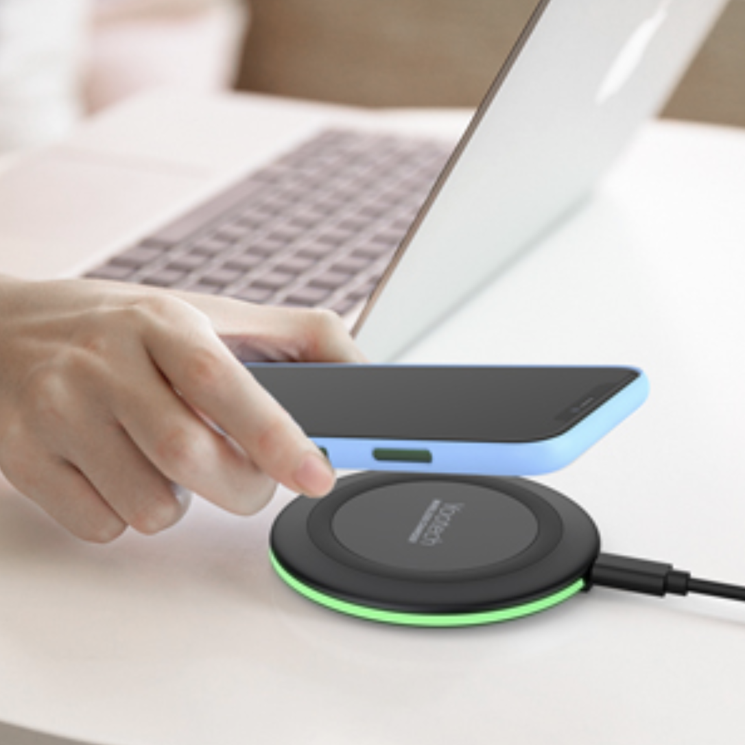 circle shaped charger resting on a desk with a phone on top of it 