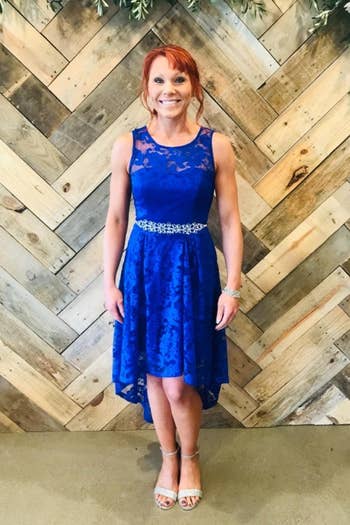 another reviewer wearing the dress in blue with a belt and heels 