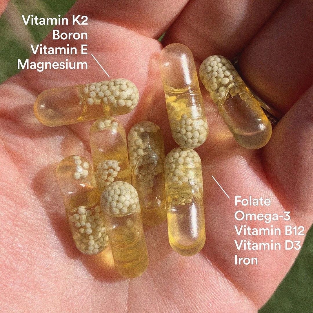 several vitamins in the palm of a model&#x27;s hand