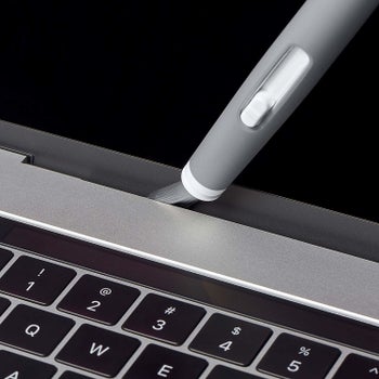 Closeup of the brush in the crevice of a laptop, illustrating how it can clean it
