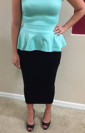 reviewer wearing the skirt in black with a peplum top 