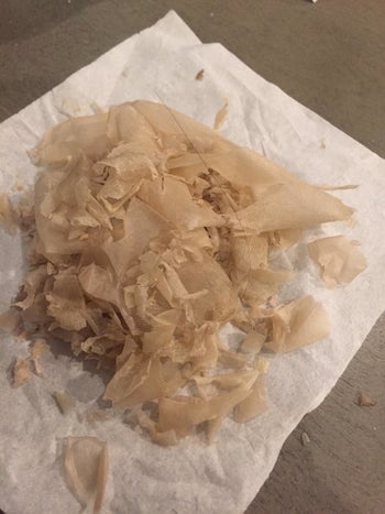 a tissue with large chunks of dead skin that peeled off after the mask