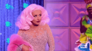 gif of christina aguilera in a sparking dress, tilting her head up and posing
