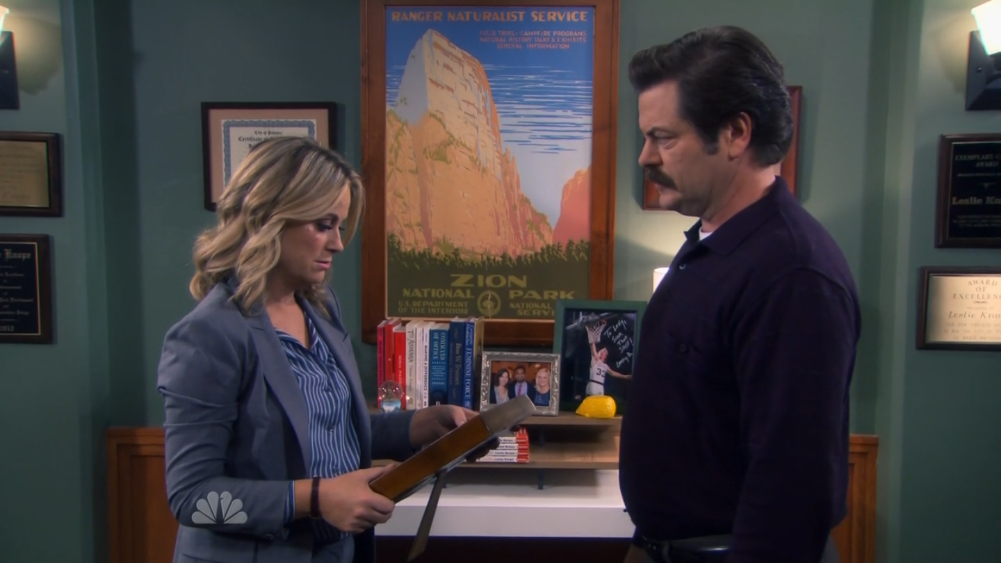 leslie looking at a photo opposite ron