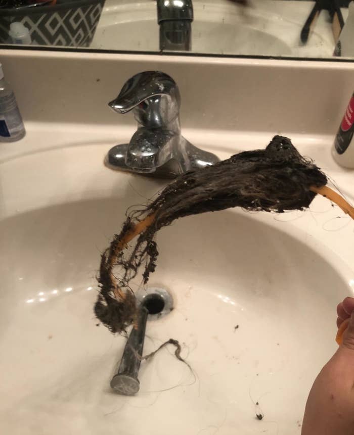 a reviewer&#x27;s drain snake covered in hair after being used to unclog a bathroom sink