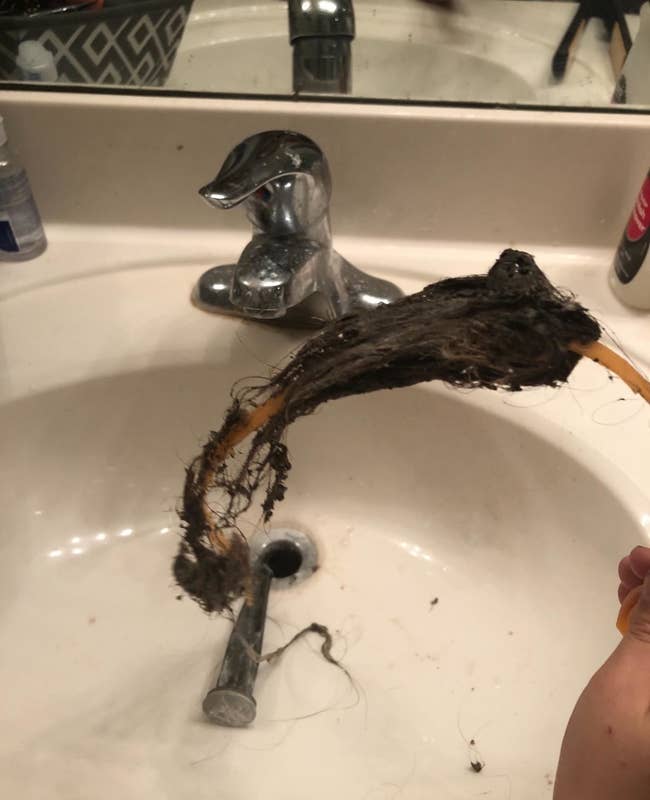 a reviewer's drain snake covered in hair after being used to unclog a bathroom sink