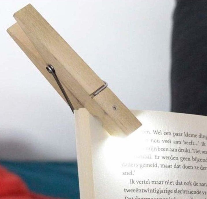 the paper clip light attached to the corner of a book