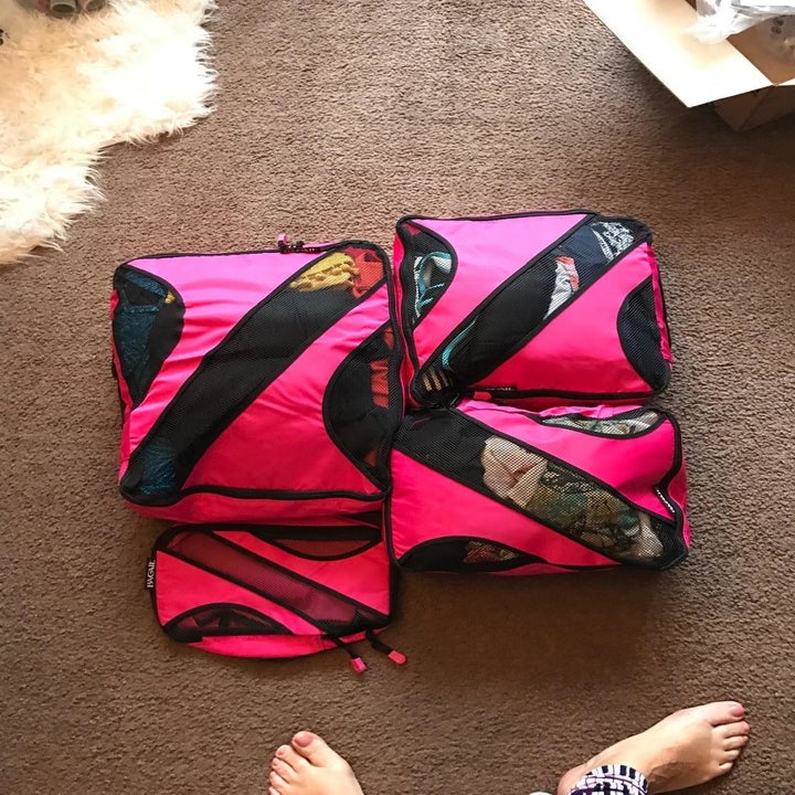 same reviewer showing giant pile of clothes neatly folded down into tiny packing cubes