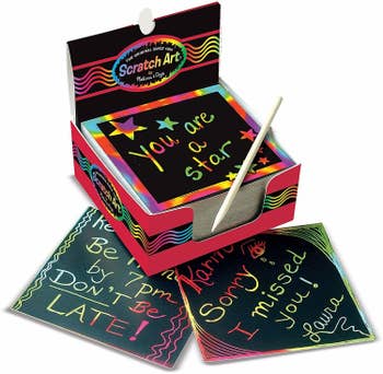A set of black cards with rainbow words scratched into them 