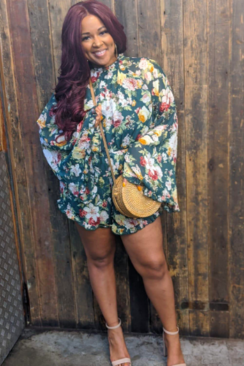 A different reviewer wearing the romper in green floral