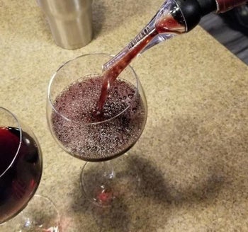 a reviewer photo of the aerator being used to pour wine into a glass