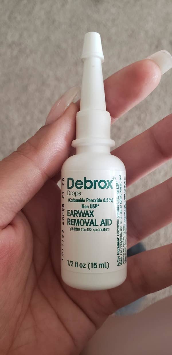 Reviewer holding up the small bottle of ear wax removal aid 