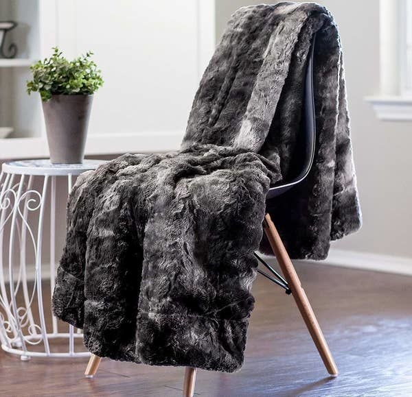the gray faux fur blanket hanging over a chair