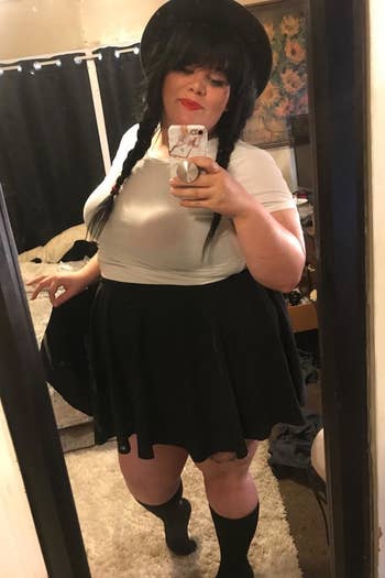reviewer wearing the black skirt with a white top 