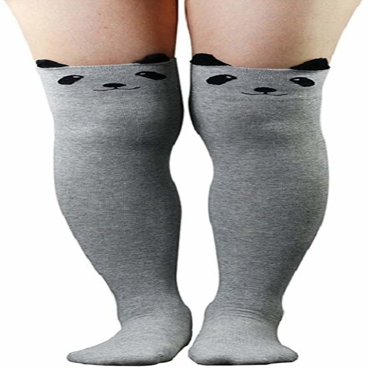 A model wearing the gray socks with panda faces and ears