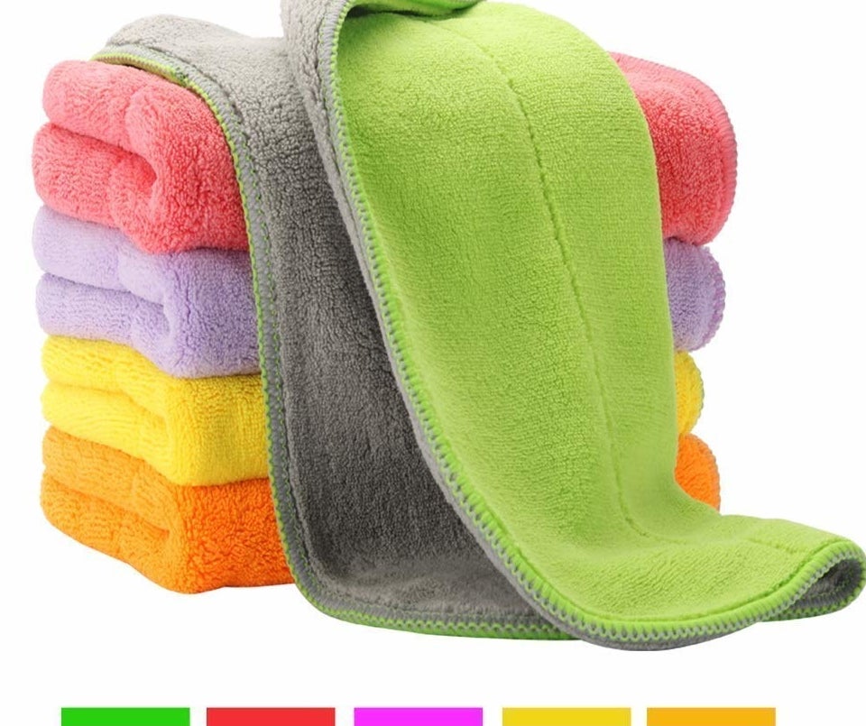 the stack of folded cleaning clothes in multiple colors