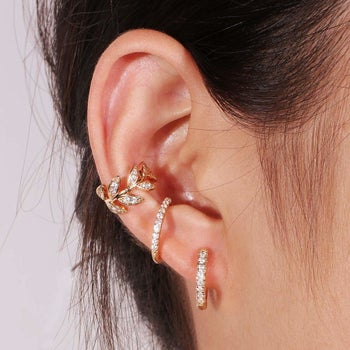 model wearing gold earring cuffs on ear