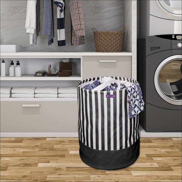 A laundry basket on the floor in front of a cabinet and a washing machine