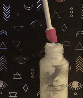 a gif of taking makeup out of bottle using the spatty