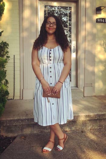 A reviewer in the spaghetti strap dress in white with vertical stripes