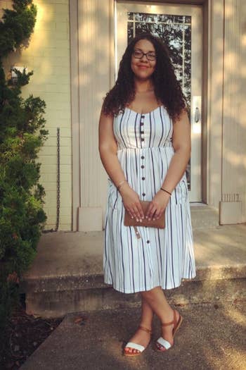 A reviewer in the spaghetti strap dress in white with vertical stripes
