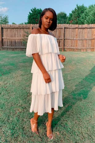 A reviewer wearing the tiered midi dress in white