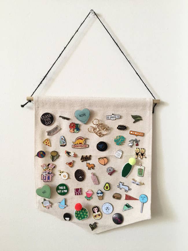 hanging pennant with tons of enamel pins on it