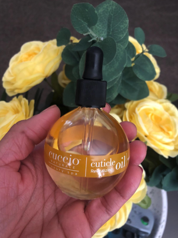 A circular bottle of cuticle oil with a dropper-style top.