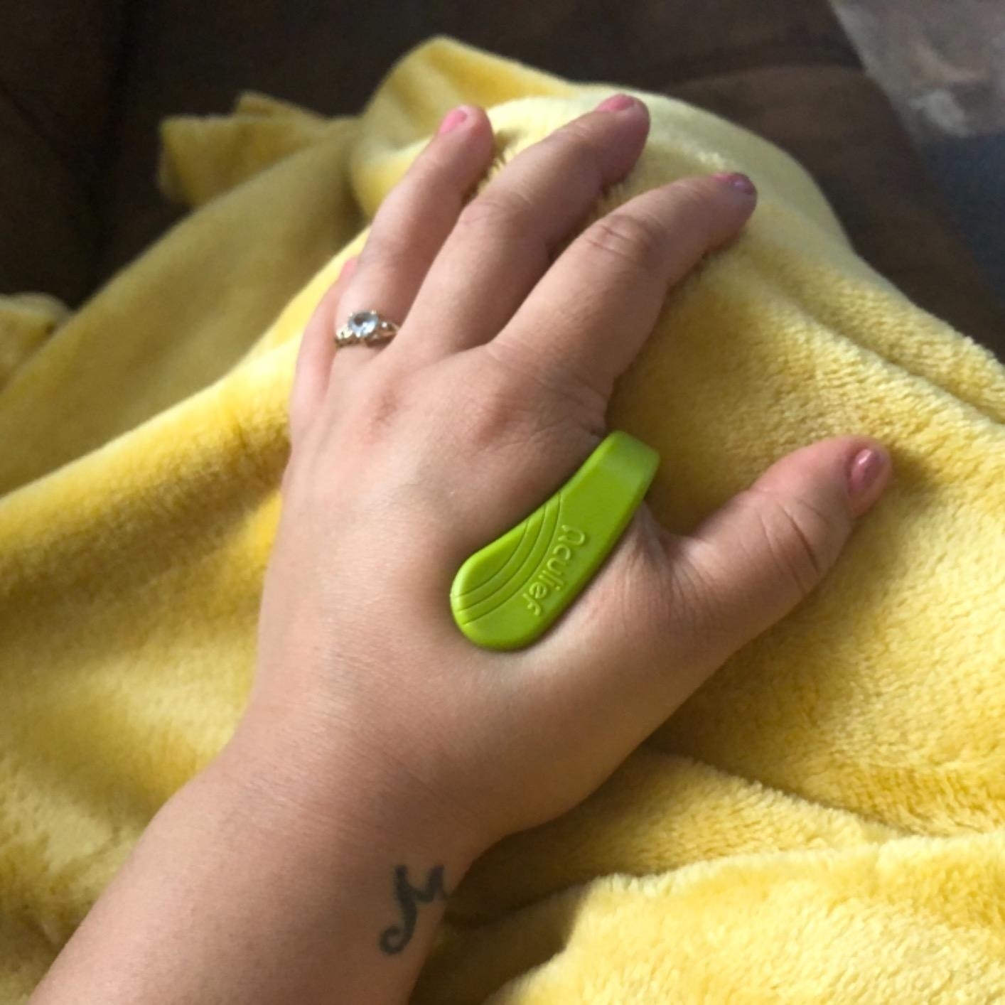 Reviewer&#x27;s hand with the U-shaped device clipped on