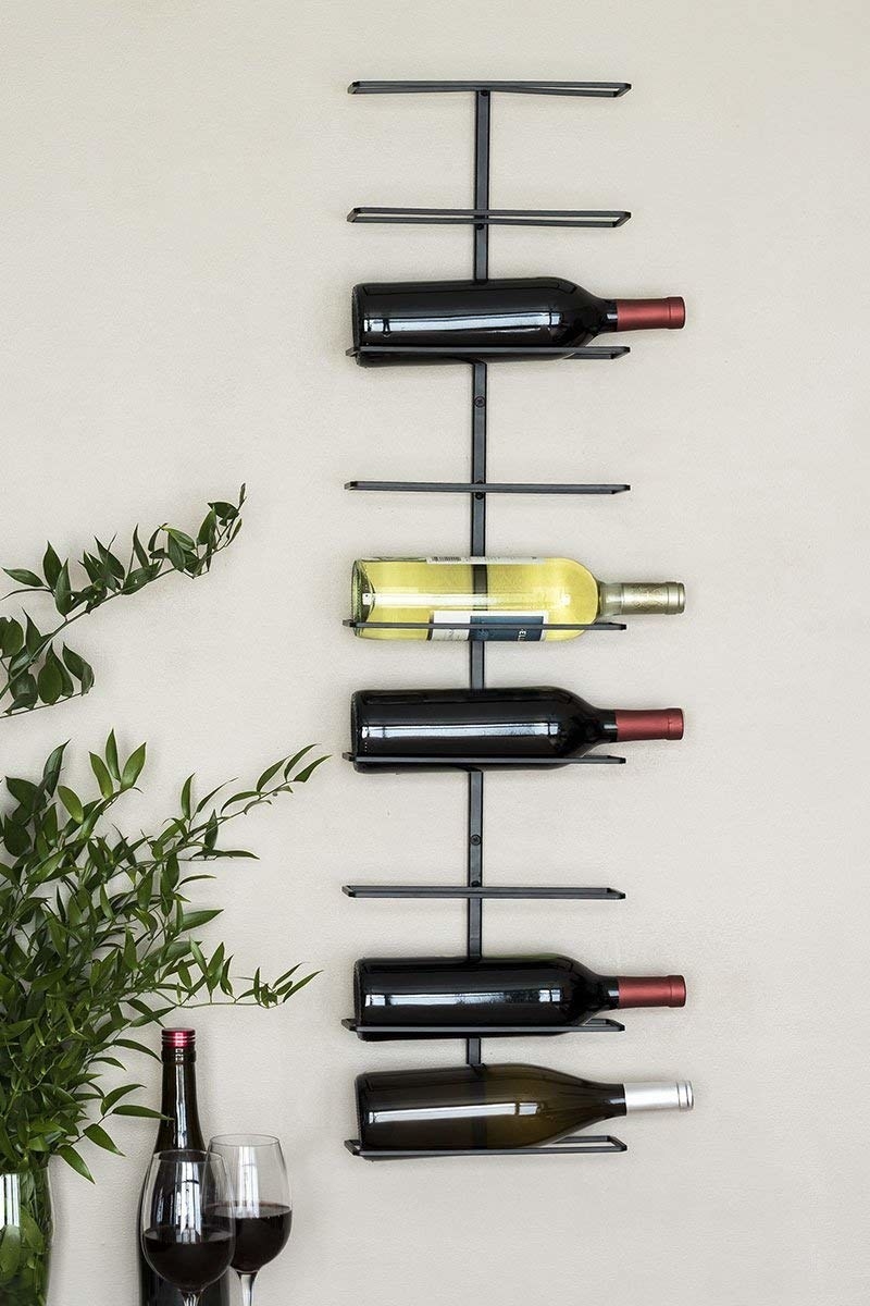 The wine rack hung on a wall and filled with several bottles of wine