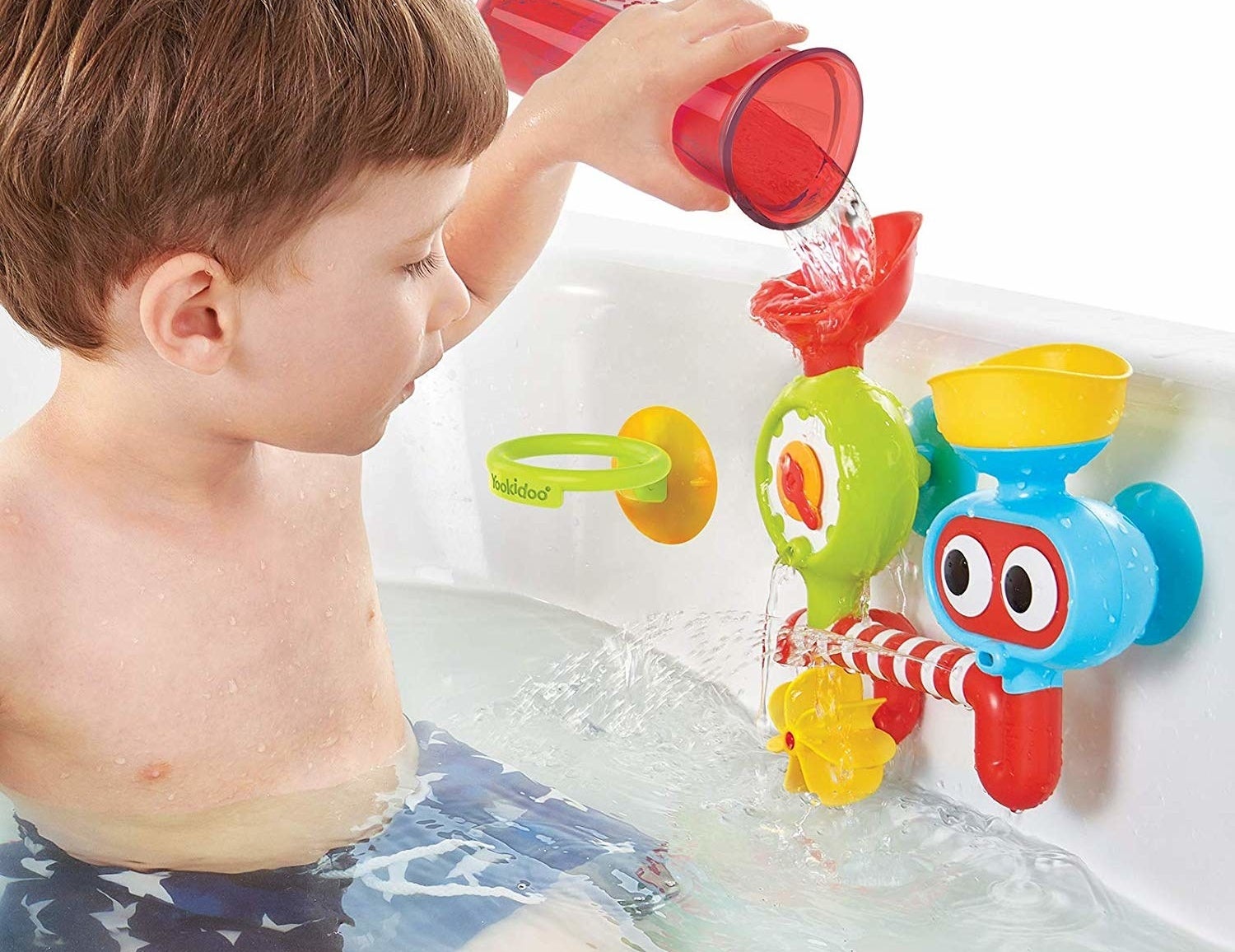 A child model in a tub pouring water into a multi-colored water lab
